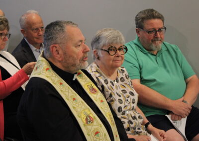 Clergy in vestments seated among the congregation
