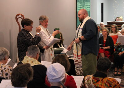 Clergy sharing Communion bread at the altar