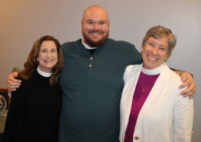 Three clergy posing together, smiling